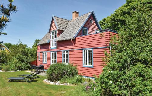 a red house with a picnic table in front of it at Holiday Home Rudbjerg Strandvej in Dannemare
