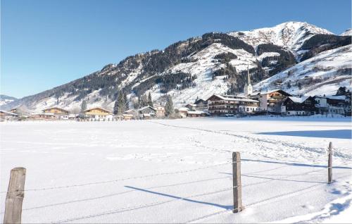 un campo cubierto de nieve con una valla frente a una montaña en Amazing Apartment In Rauris With Kitchen, en Rauris