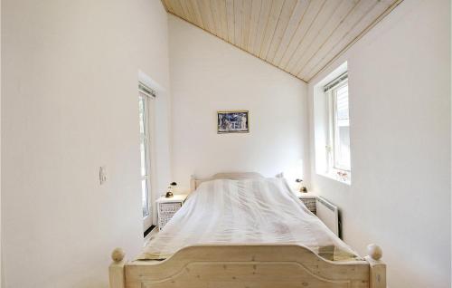 a bed in a white room with two windows at Holiday Home Lyngshuse Xi in Kølkær