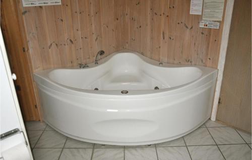a large white tub in a bathroom with wooden walls at Beautiful Home In Middelfart With Sauna in Voldby