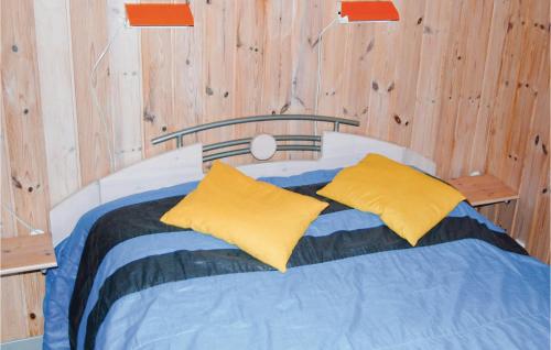 a bed with two yellow pillows on top of it at Stunning Home In Middelfart With 4 Bedrooms, Sauna And Wifi in Voldby