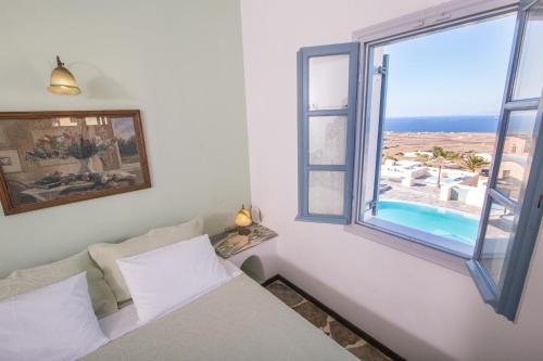 伊亞的住宿－安尼摩沙別墅酒店，一间卧室设有一张床和一个美景窗户。