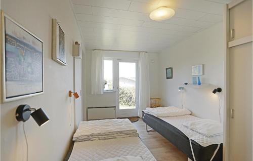 Habitación pequeña con 2 camas y ventana en 3 Bedroom Gorgeous Home In Allinge, en Allinge