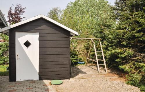 a small shed with a ladder next to it at Beautiful Home In Middelfart With Sauna in Voldby