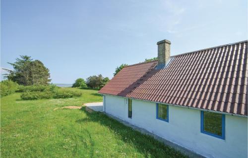 a house with a red roof on a green field at Holiday Home Veslos With Fireplace I in Højstrup