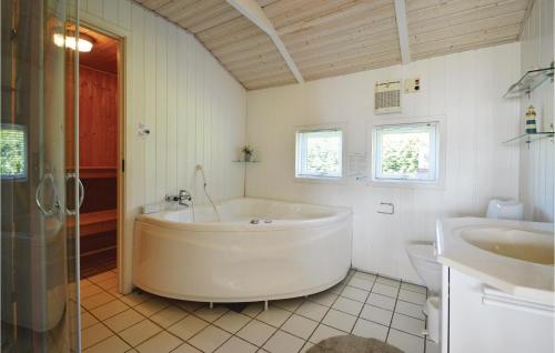 SjølundにあるCozy Home In Sjlund With Saunaの白い広いバスルーム(バスタブ、シンク付)
