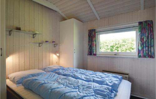 SjølundにあるCozy Home In Sjlund With Saunaの窓付きの部屋にベッド付きのベッドルーム1室があります。