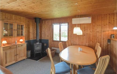 a dining room with a table and a stove at Holiday Home Svenstibakkevej Frøstrup Iv in Lild Strand