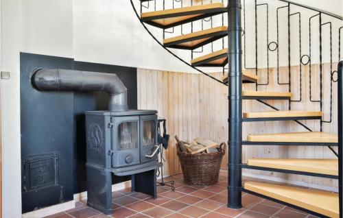 a wood stove in a room with a staircase at Two-Bedroom Holiday Home In Lemvig in Nørby