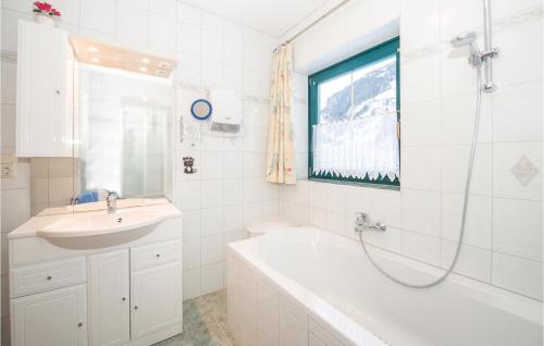 La salle de bains blanche est pourvue d'une baignoire et d'un lavabo. dans l'établissement 2 Bedroom Awesome Apartment In Rauris, à Rauris