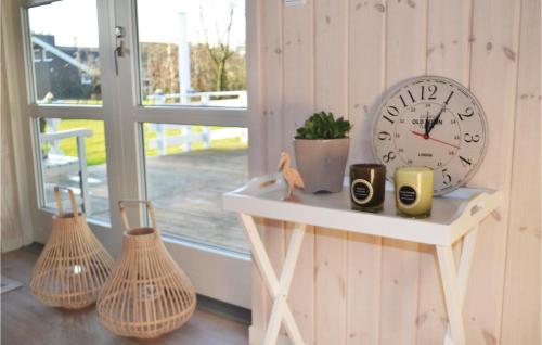 a clock sitting on a shelf next to a window at Holiday Home Solbærvangen V in Ovtrup