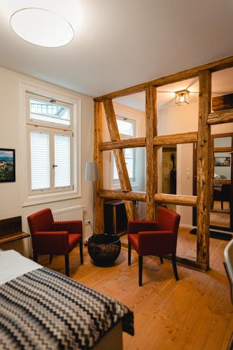 a bedroom with a bed and two red chairs at Ferienwohnungen an der Salvatorkirche - zentrales Apartmenthaus mit Terrasse in Coburg