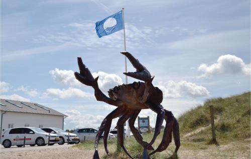 a statue of a crab with a flag in a parking lot at Holiday Home Østersvej Fjerritslev Xii in Slettestrand
