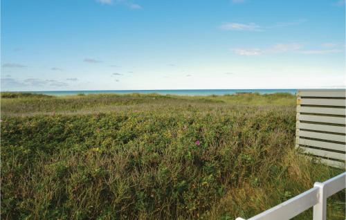 a field of tall grass with the ocean in the background at Beautiful Home In Hjørring in Lønstrup
