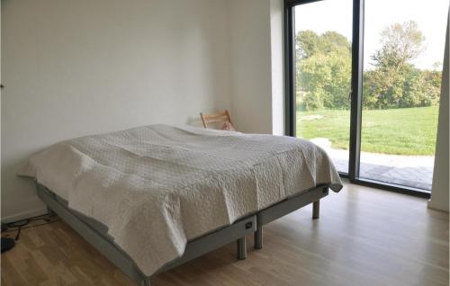 łóżko w białym pokoju z dużym oknem w obiekcie Beautiful Home In Hesselager With Kitchen w mieście Hesselager