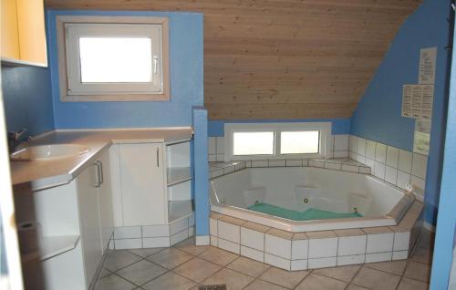 La salle de bains est pourvue d'une baignoire et d'un lavabo. dans l'établissement Amazing Home In Blvand With Kitchen, à Blåvand
