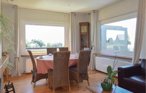a dining room with a table and two large windows at Le Rosier in Ovifat