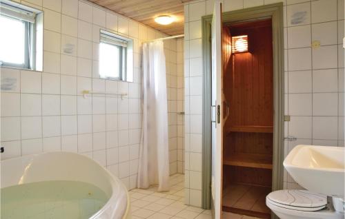 スナーヴィグにあるLovely Home In Ringkbing With Saunaのバスルーム(バスタブ、トイレ、シンク付)