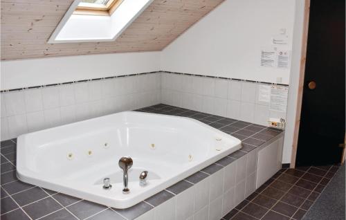 a bath tub in a bathroom with a skylight at Cozy Home In Vggerlse With Wifi in Bøtø By