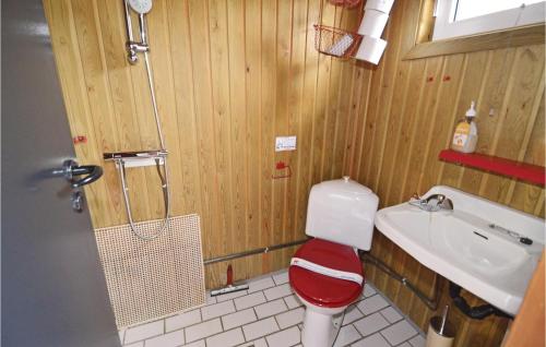 uma casa de banho com um WC vermelho e branco e um lavatório. em 2 Bedroom Stunning Home In Fars em Hvalpsund