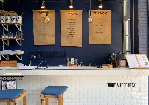 a restaurant with a blue wall with a counter and stools at Stay Samed Hostel in Ko Samed