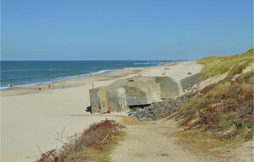 a building on a beach next to the ocean at Apartment Badevej X in Søndervig