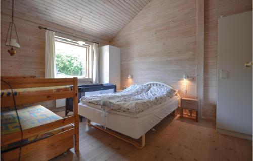 エーベルトフトにあるAwesome Home In Ebeltoft With 2 Bedrooms And Wifiのベッドと窓が備わる小さな客室です。