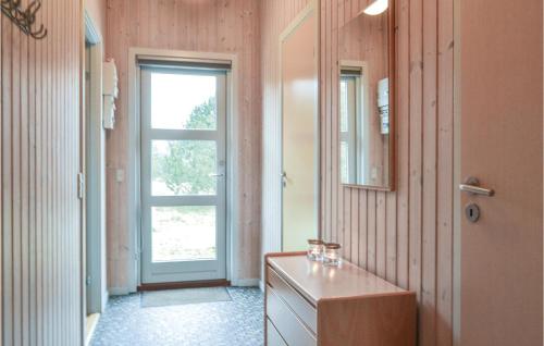 a bathroom with a sink and a mirror and a door at Nice Home In Hvide Sande With 3 Bedrooms And Wifi in Bjerregård