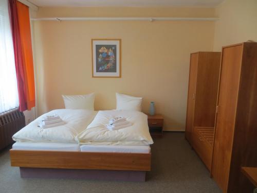 a bedroom with a bed with white sheets at Heidehotel Letzlingen in Letzlingen