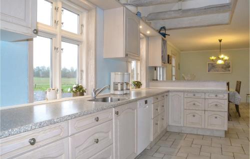 a kitchen with white cabinets and a sink and a window at Haugstrupgrd in Filskov