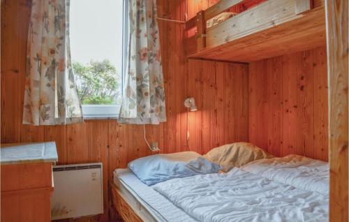 スナーヴィグにあるToms Hytteの窓付きの木造の部屋のベッド1台