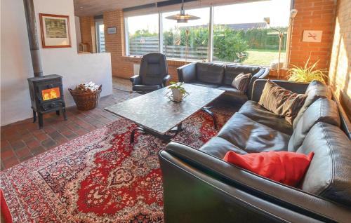 a living room with a couch and a table and a fireplace at Two-Bedroom Holiday Home In Sydals in Skovbyballe