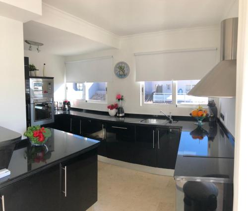 a kitchen with black cabinets and a sink at Penthouse La Paz 9 - Castle view in Moraira