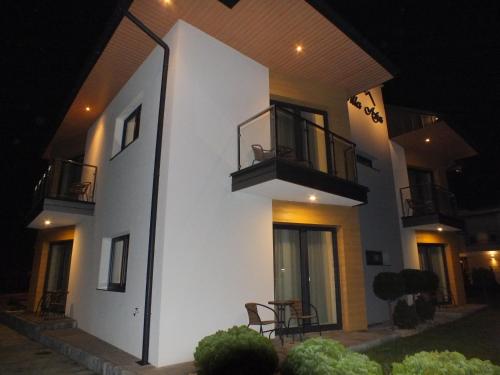 a white building with a balcony at night at Willa Asia in Sromowce Niżne