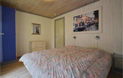 a bedroom with a bed and a painting on the wall at Beautiful Home In Fan With 3 Bedrooms, Sauna And Wifi in Fanø