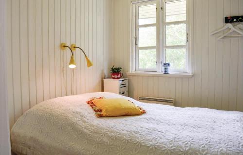 a bedroom with a bed with a yellow pillow on it at Lovely Home In Rm With Wifi in Bolilmark