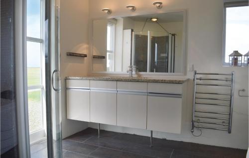 uma casa de banho com um lavatório branco e um espelho. em Beautiful Home In Lemvig With Kitchen em Nørby