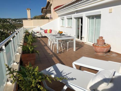 a balcony with a table and chairs on a building at Penthouse La Paz 9 - Castle view in Moraira
