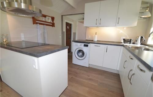 kuchnia z białymi szafkami i pralką i suszarką w obiekcie Four-Bedroom Holiday Home In Vordingborg w mieście Vordingborg