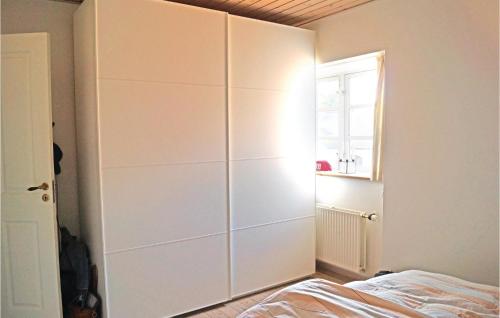a bedroom with a large white cabinet next to a bed at Stunning Apartment In Middelfart With Kitchen in Middelfart