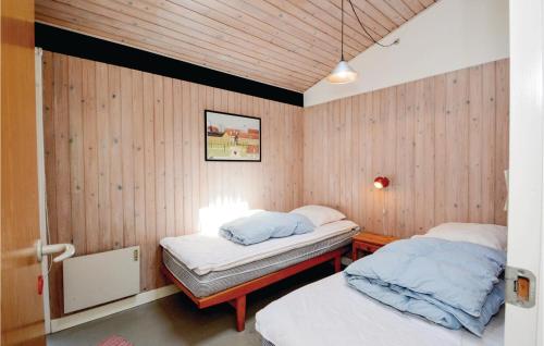 HejlsにあるPet Friendly Home In Hejls With Wifiのウッドパネルの壁の客室で、ベッド2台が備わります。
