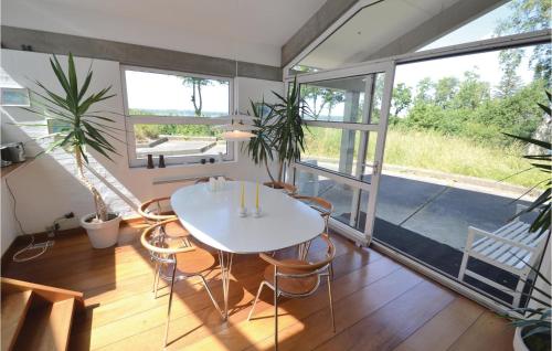 a room with a white table and chairs and windows at Holiday Home Hesselvej in Hvalpsund