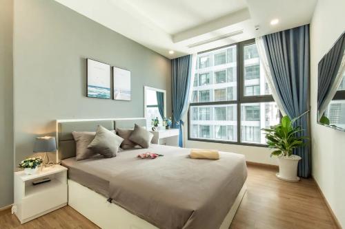 1 Schlafzimmer mit einem großen Bett und 2 Fenstern in der Unterkunft Vinhomes Green Bay Apartment - by Bayhomes in Hanoi