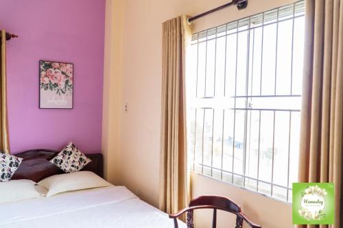 a bedroom with a bed and a large window at Can Tho Orchid Garden Homestay in Can Tho