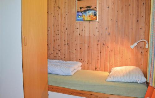 a room with a wooden wall with two beds at 3 Bedroom Gorgeous Home In Vggerlse in Marielyst