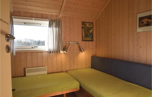 a small room with two beds and a window at 2 Bedroom Awesome Home In Hovborg in Hovborg