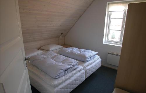 two beds in a small room with a window at Holiday Home Sdr Frankel Rømø Denm in Havneby