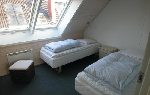 ロモ・キルケビーにあるAwesome Home In Rm With 3 Bedrooms, Sauna And Wifiのベッド2台と窓が備わる小さな客室です。