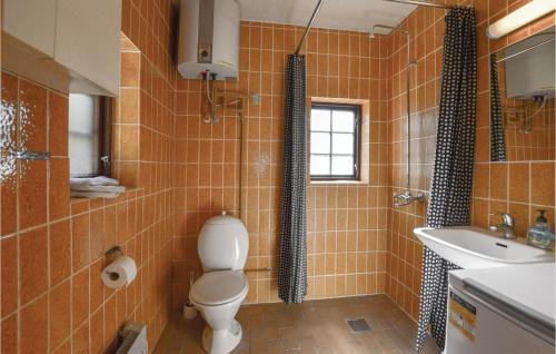 KlintにあるBeautiful Home In Nykbing Sj With 2 Bedrooms And Wifiのオレンジ色のタイル張りのバスルーム(トイレ、シンク付)