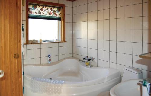 a white tub in a bathroom with a toilet at 3 Bedroom Stunning Home In Pandrup in Rødhus